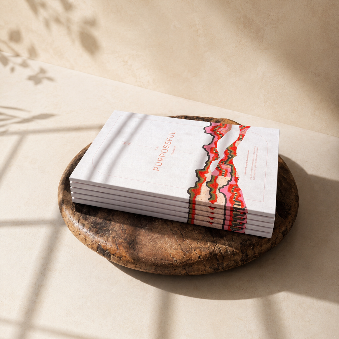 A stack of white brochures or booklets with a red and orange abstract wave design and the word 'CUPOLONI' visible on the cover, resting on a round wooden tray against a warm beige wall with soft shadow patterns.