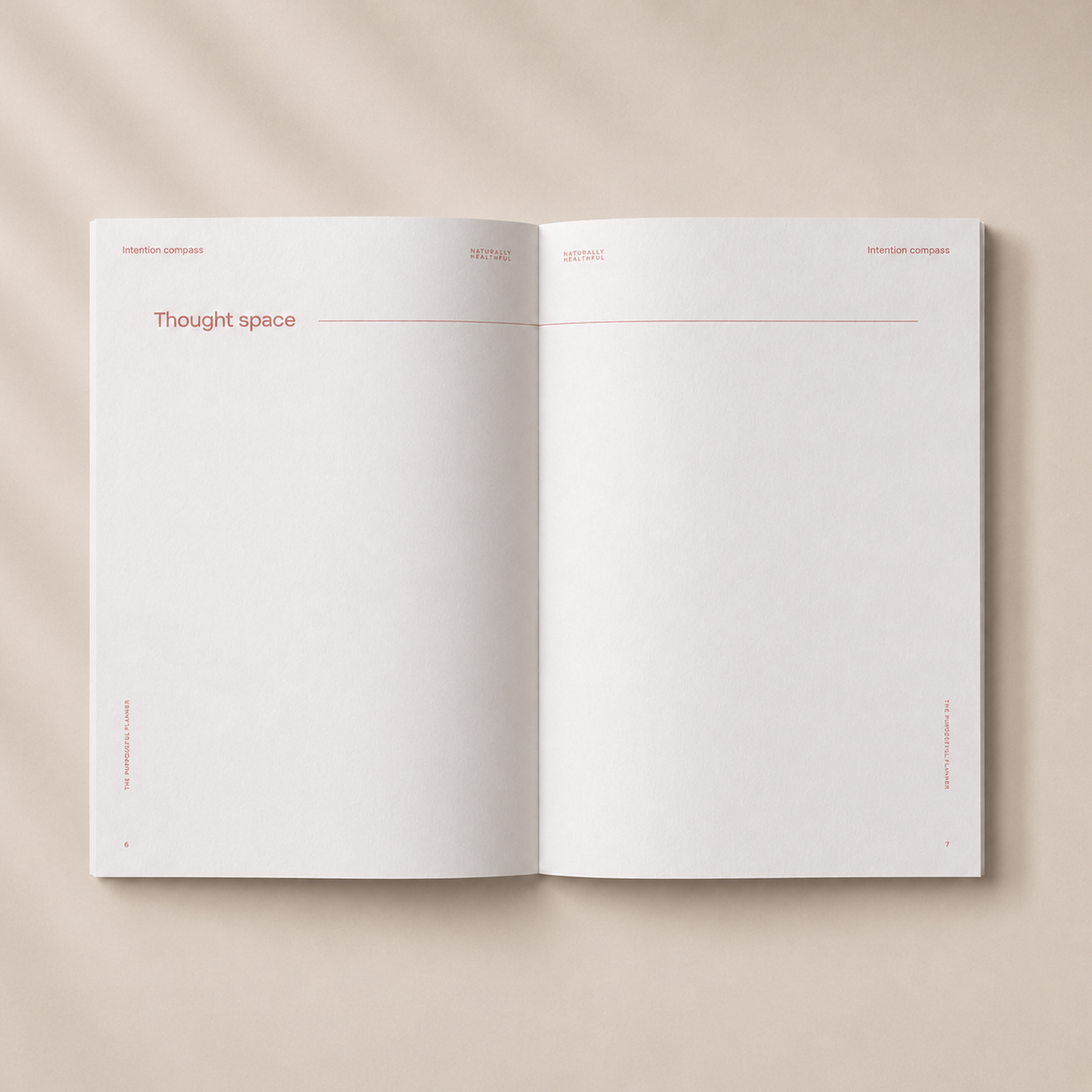 An open blank journal or notebook spread on a warm beige background with soft diagonal shadows. The pages are white with very minimal pink text and thin pink lines, including the heading 'thought space' on the left page.