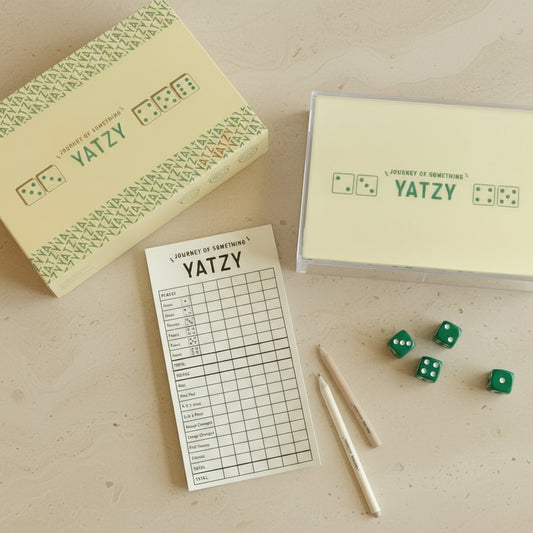 Yatzy game set with dice, score sheets, and packaging on a white background