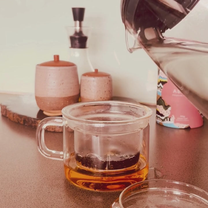 Loose leaf tea being brewed in a glass pot